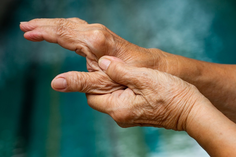 Senior woman's left hand massaging her thumb finger, suffering from arthritis pain.