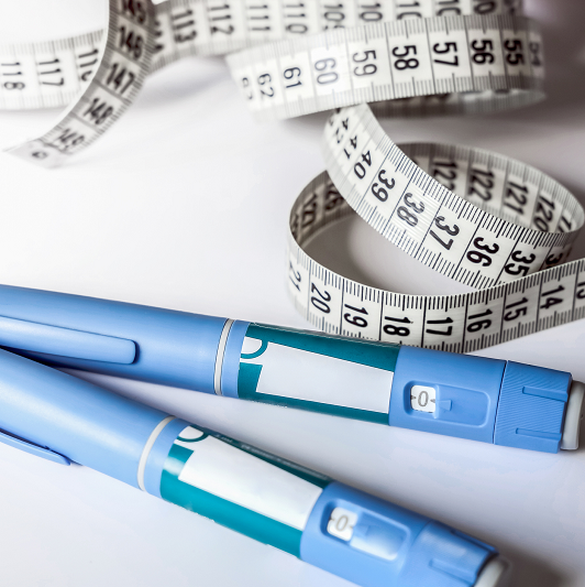Ozempic or weight loss injection pens with some tape measures laid around them.