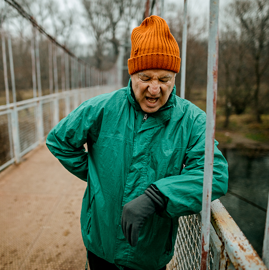 An older man, resting on a bridge while out of breath.