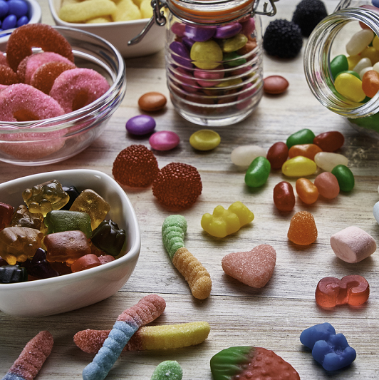 Close-up view of an assortment of colorful jellybeans, lollipops, candies and marshmallows.