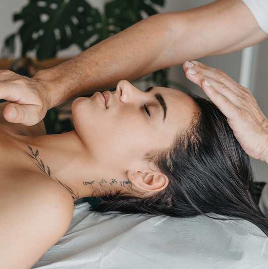 Side profile of a woman while receiving energy in a Reiki therapy.