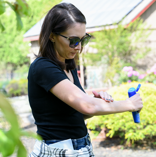 Woman applying sunscreen to her arm.