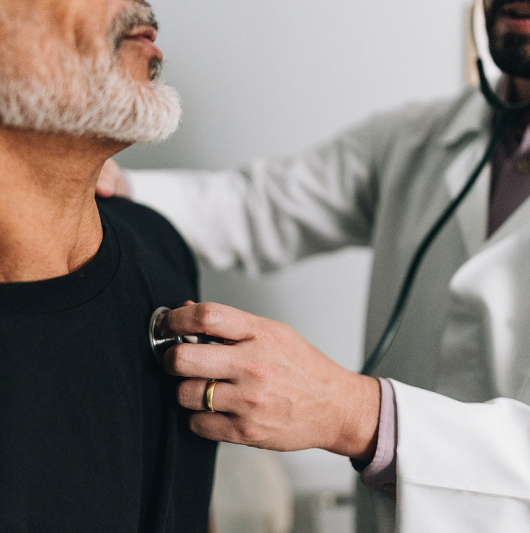 Doctor using a stethoscope to listen to a patient's heart.