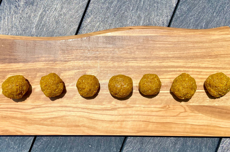 A platter of round, golden-colored turmeric protein bites.