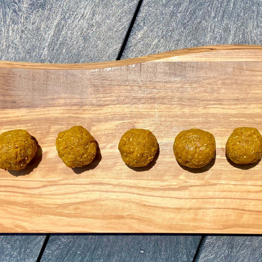 A platter of round, golden-colored turmeric protein bites.