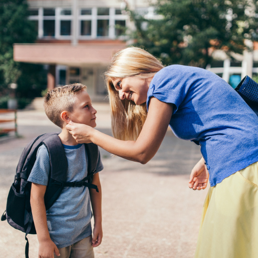 A mom reaches out to comfort her young son, who is going back to school.