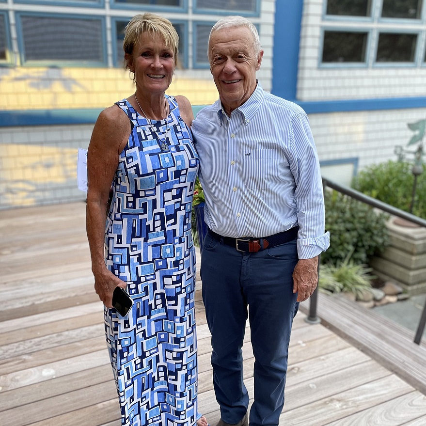 Michael (Mike) Armellino standing and smiling with a woman in front of a building