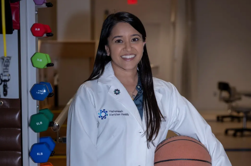 Family medicine specialist Darshini Shah, M.D. holds a basketball while smiling at the camera.