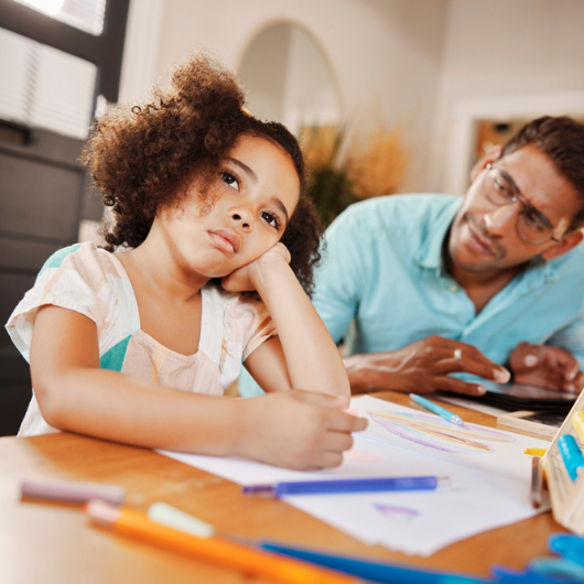 Little girl stares off into the distance, looking bored, while her father watches her.