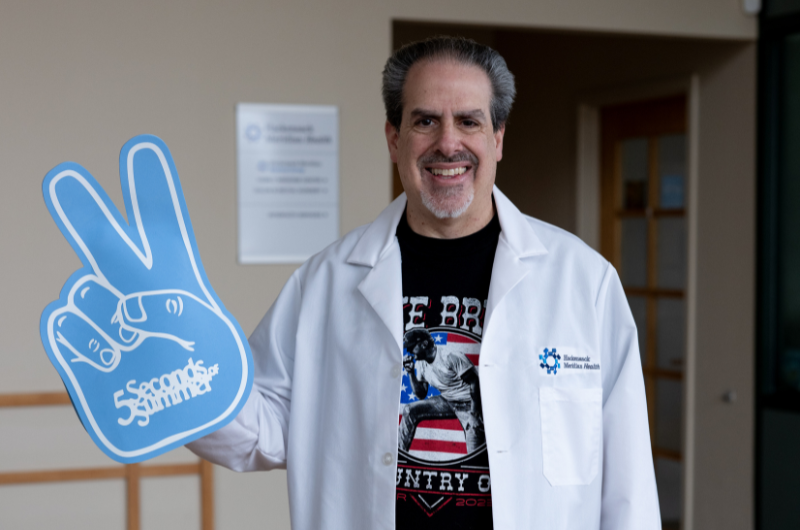 Family medicine specialist Michael Raguso-Failla, M.D. wears a foam finger that reads ‘5 Seconds of Summer’.