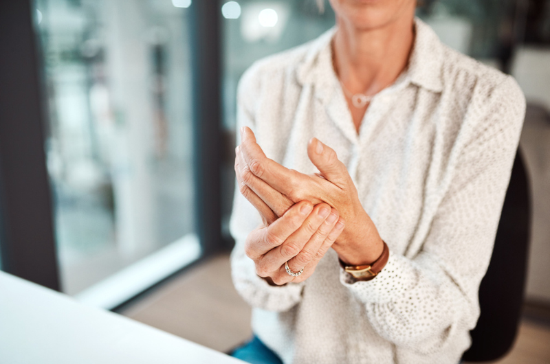 Closeup shot of an unrecognizable businesswoman experiencing discomfort in her hand while working in an office.