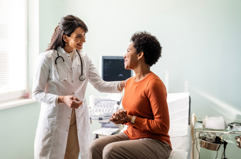 A female primary care physician reassures a female patient.