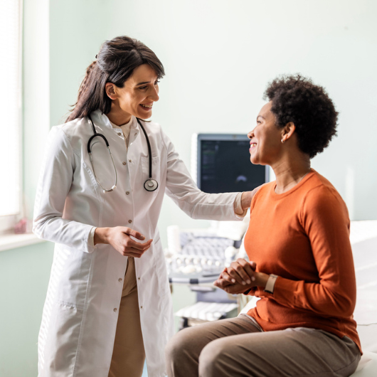 A female primary care physician reassures a female patient.