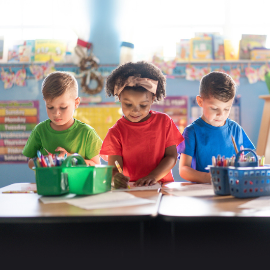 Three preschoolers actively learning and growing in a nurturing daycare environment.