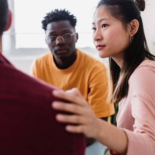 Meeting of young people in group therapy supporting each other.