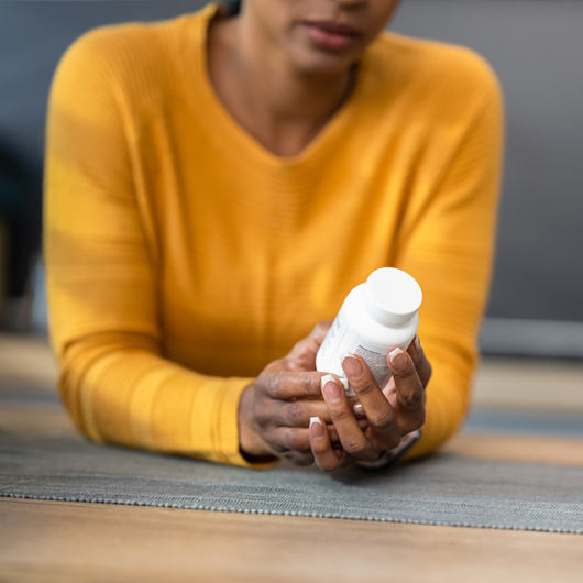Woman holding bottle of zinc supplements