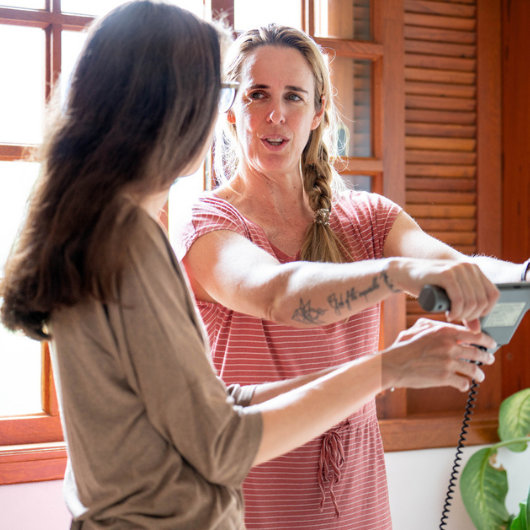 Female nutritionist speaking with a client using a body composition monitor.
