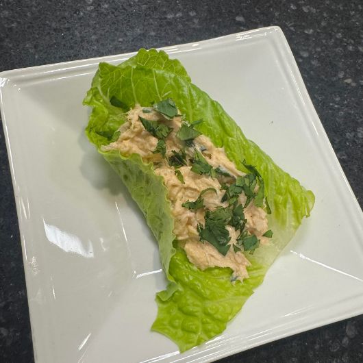 Image shows a close up of the bang bang chicken salad in a lettuce wrap on a plate.