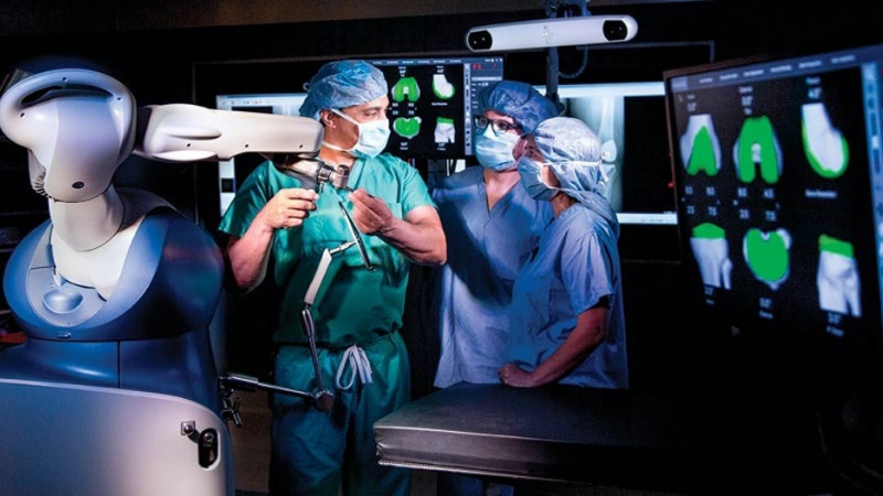 A joint replacement surgical team discusses the procedure in an operating room.