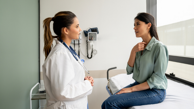 Latin American woman explaining to her doctor her symptoms in a consultation.