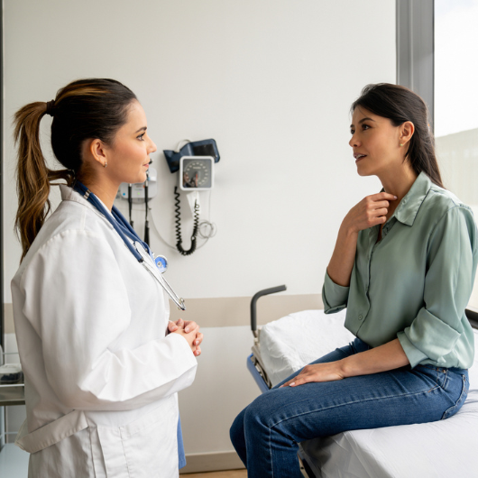 Latin American woman explaining to her doctor her symptoms in a consultation.