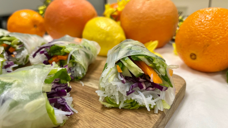 A side view of homemade spring rolls on a butcher board.