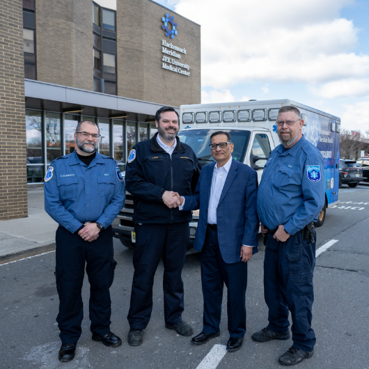 Kash Saraiya and three EMS personnel stand outside JFK University Medical Center.