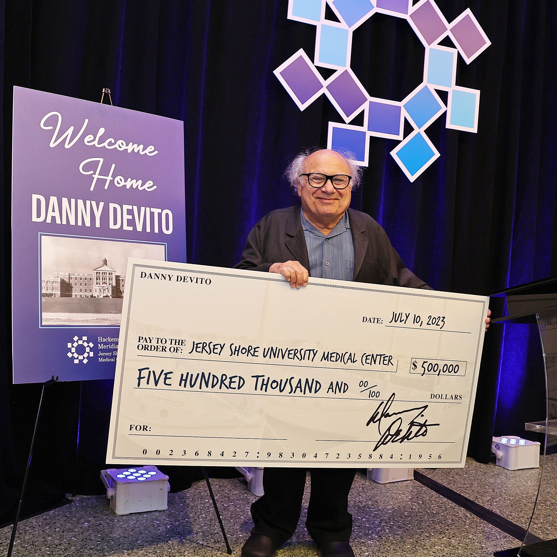 Danny DeVito with a check for Jersey Shore University Medical Center