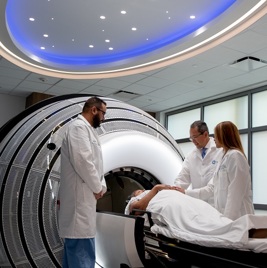 ZAP-X and Synaptive MRI imaging machine. A patient laying on their back about to have a scan, with physicians around them.
