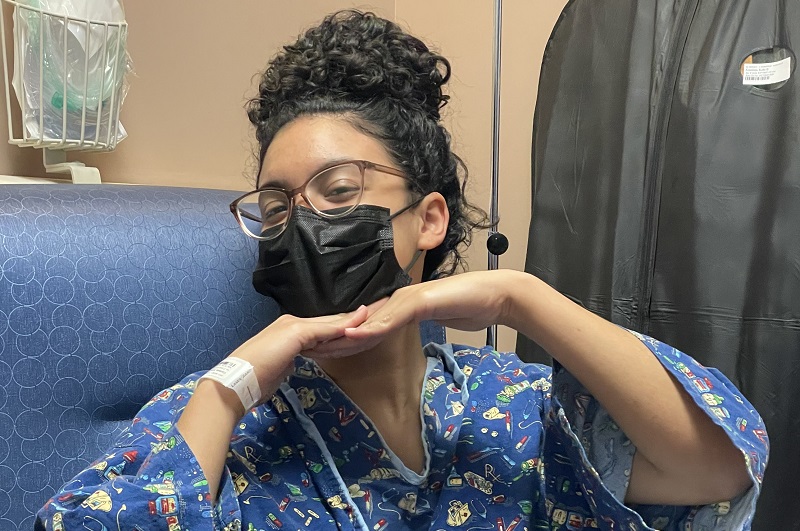 Young patient smiling with a mask on after ACL surgery.