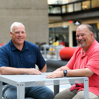 Vinnie and Ken Hager sitting at a table together