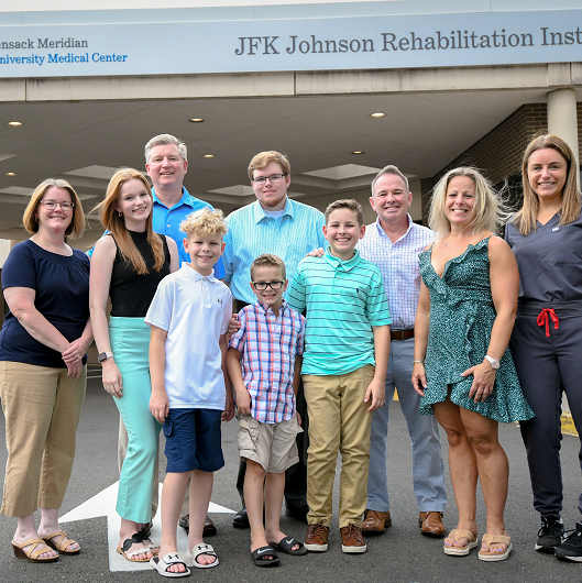 The Rydarowski family standing outside of JFK Johnson Rehabilitation Institute 