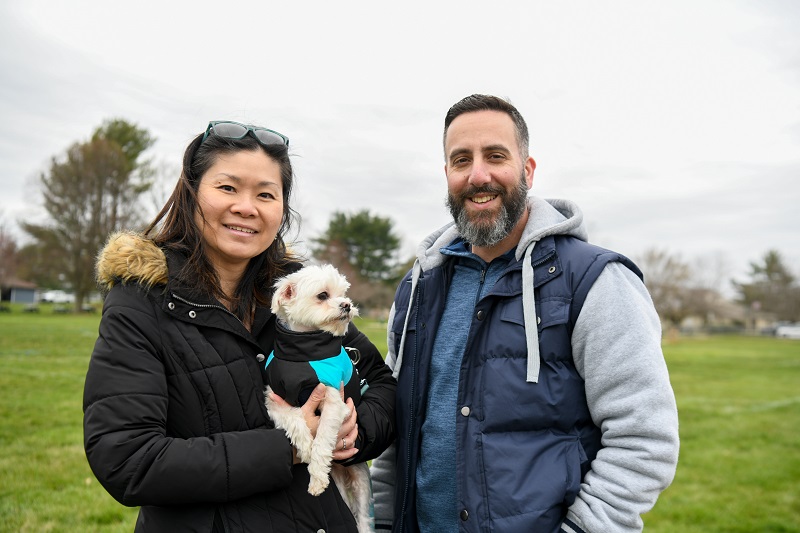 Kitty Chow with her dog and husband in the park.
