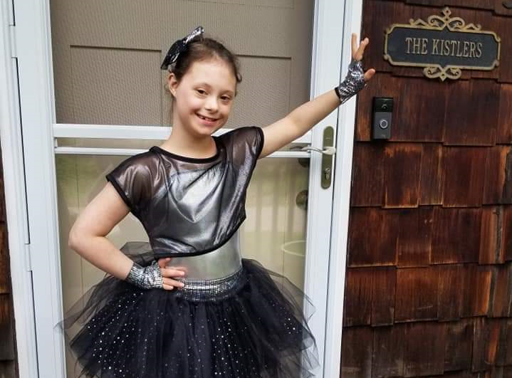 Ally Kistler standing outside her house, in a dance pose for a dance recital
