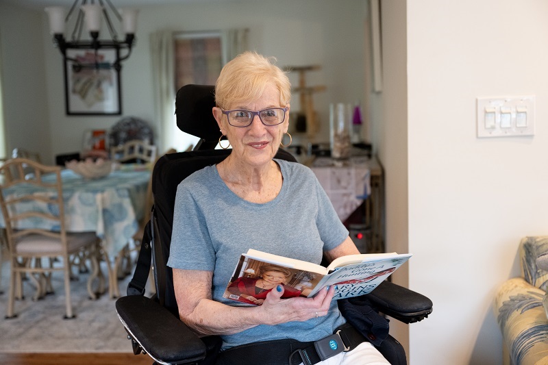Patient Emily Turner holding a book and smiling.