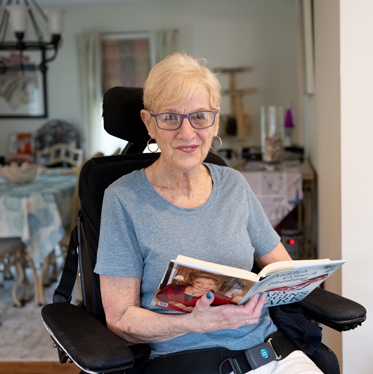 Patient Emily Turner holding a book and smiling. 