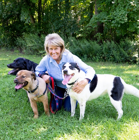 Lisa Hahn hugging her dogs outside, while on a walk.