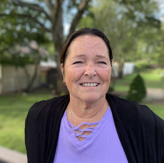 Terri Apuzzu smiling outside on a sunny day.