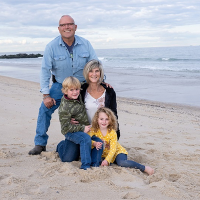 Dawn and her family at the beach smiling together.