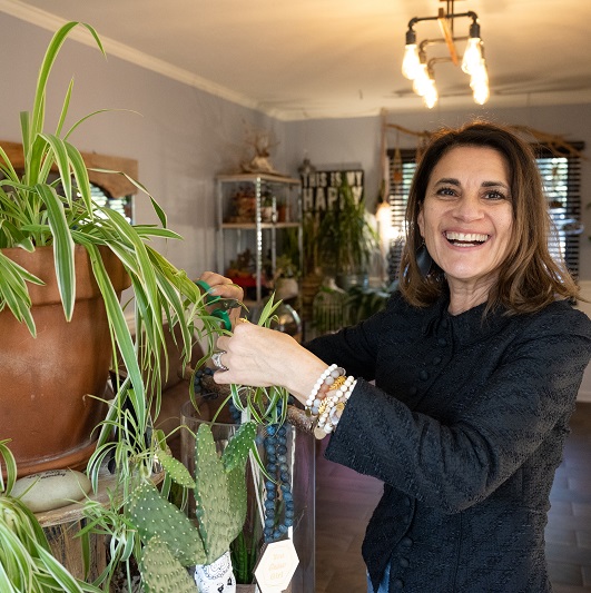 Maritza smiling and tending to her plants.