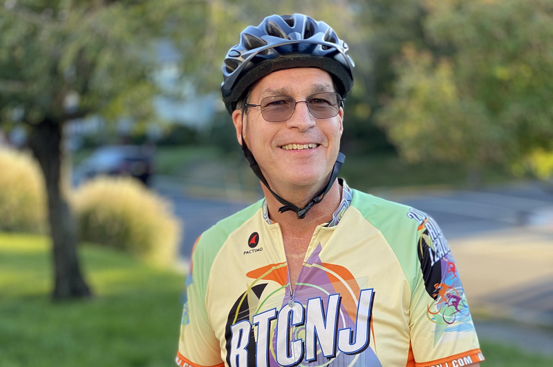 Michael Kerlen in his cycling gear, smiling with his bike.