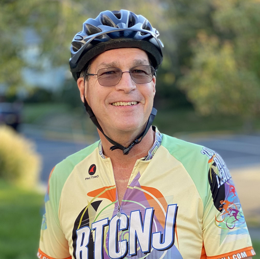 Michael Kerlen in his cycling gear, smiling with his bike.