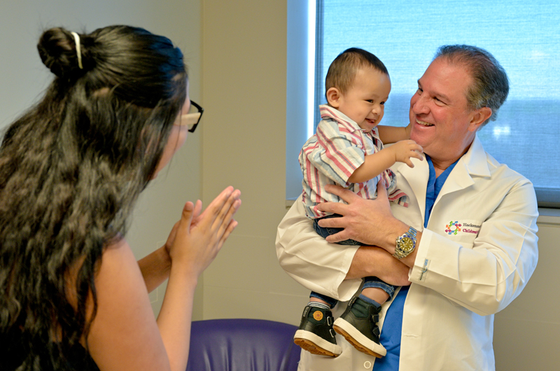A brown-haired baby boy named Ethan Barnuevo Mija, his mother and his doctor enjoy a happy moment together.