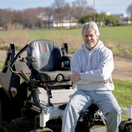 58-year-old Matawan, New Jersey, man sits on his riding lawnmower.