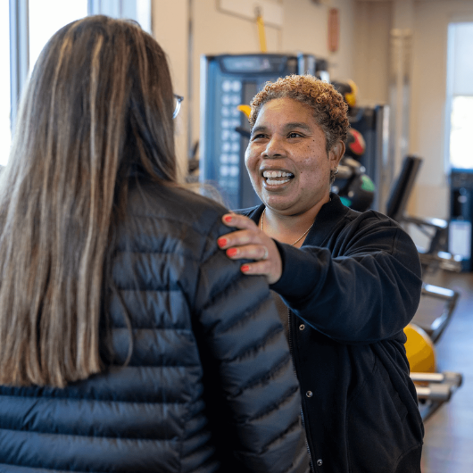Aretha Watson, Ph.D., smiles and puts her hand on a woman’s shoulder.