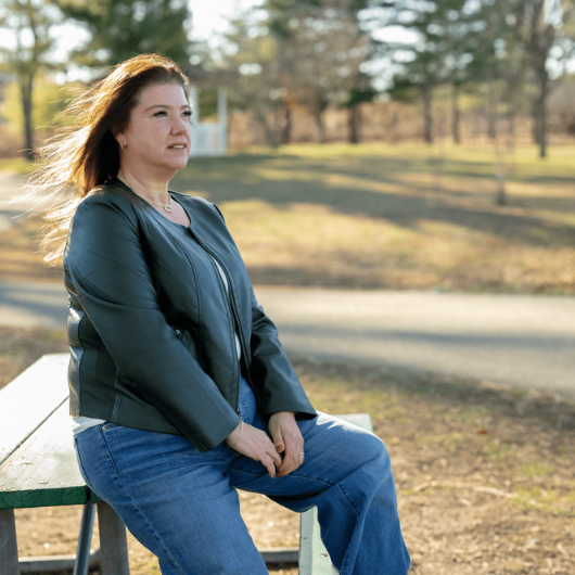 53-year-old Andrea Loberbaum of Upper Saddle River, New Jersey, leans against a picnic table.