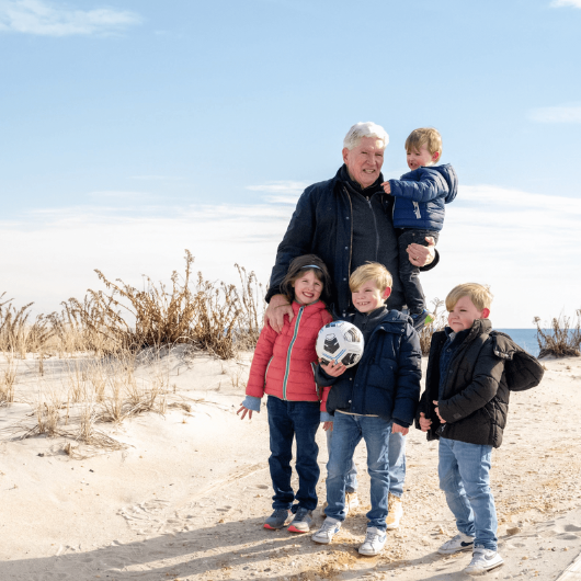 74-year-old Gene Hayman plays with his four grandchildren on the beach.