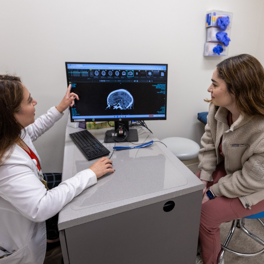 Lauren Trachtenberg, M.D., looks at an image of the brain with Christine Greiss, D.O.   