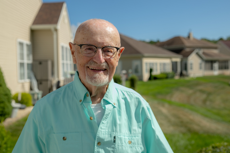 Nick smiling outside his home.