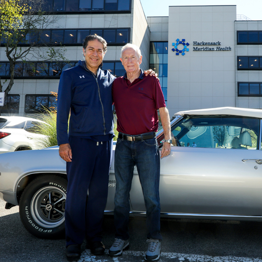 Dan Cooney outside hospital in front of Camarro